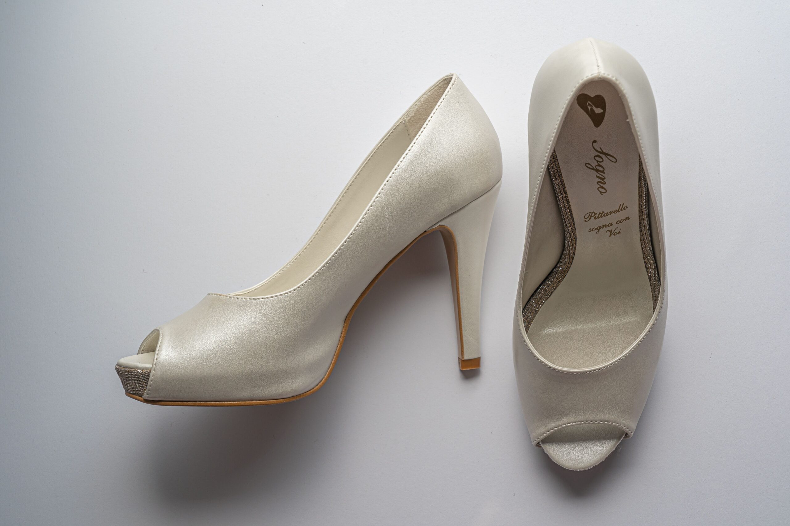 Elegant white bridal high heels with peep-toe design, perfect for weddings.